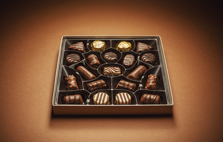 Closeup view of box of chocolates, studio composition on brown background.の写真素材