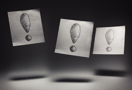 Exclamation marks drawn on paper, on gray background. の写真素材