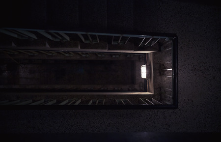 Dark ambiance of an old building interior, details of a staircase and lights. の写真素材