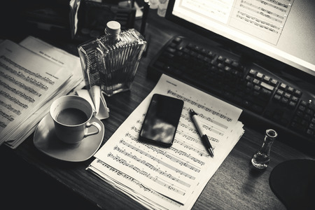 Details of a table of a composer, music note sheets and computer and other lifestyle objects.の写真素材