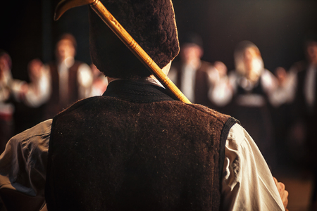 Details of dancer's back and hat holding a stick, dressed in traditional Serbian dress.の写真素材