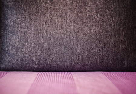 Abstract composition of big gray pillow on purple bed.の写真素材