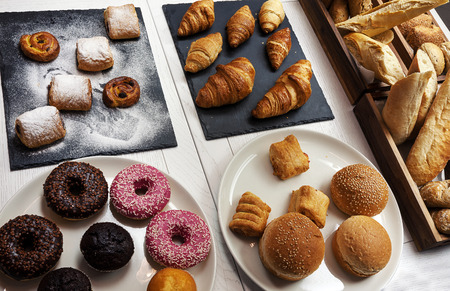 A lot of various pastry and colorful cakes on table.の写真素材