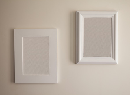 Closeup view on two empty picture frames on white wall.の写真素材