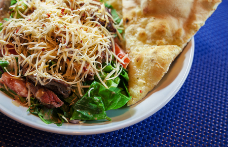 Pieces of meat with pasta and green salad in white plate.の写真素材