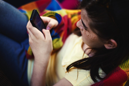 View from above on young girl messaging on phone.の写真素材