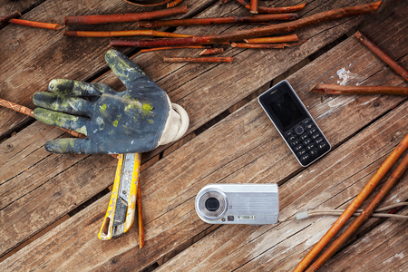 Old wooden table, some withes,tools and personal gadgets.の写真素材