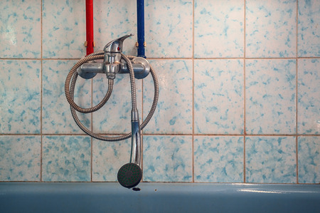 View on an old bathroom faucet and part of tiled ceramic wall.の写真素材