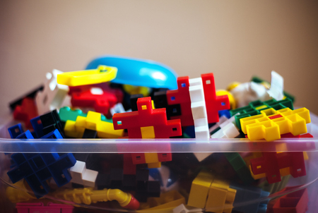 Closeup of various colorful puzzles in plastic container.の写真素材