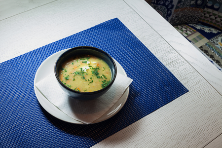 Tasty hot chicken soup in pottery plate on table.の写真素材