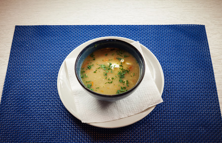 Tasty hot chicken soup in pottery plate on table.の写真素材