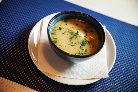 Tasty hot chicken soup in pottery plate on table.の写真素材