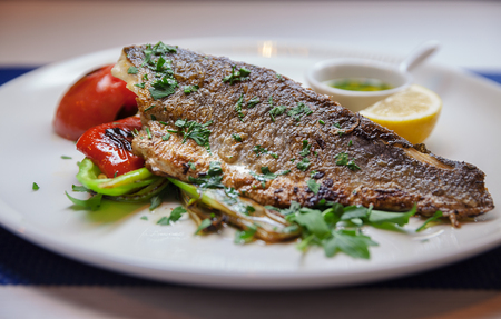 Piece of fried fish with pepper and oil.の写真素材