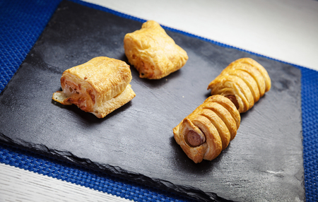 Pastry with meat on ceramic black plate.の写真素材