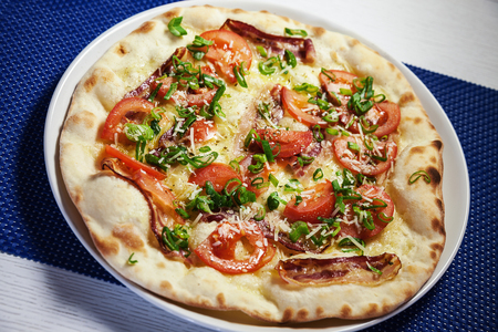 Classical pizza with bacon, tomato and pepper plate.の写真素材