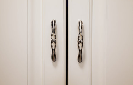 Closeup view on new stylistic hinges on white closet.の写真素材