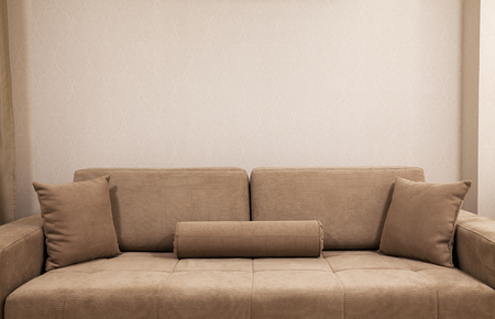 Modern and new couch in front of wall with decorative wallpapers.の写真素材