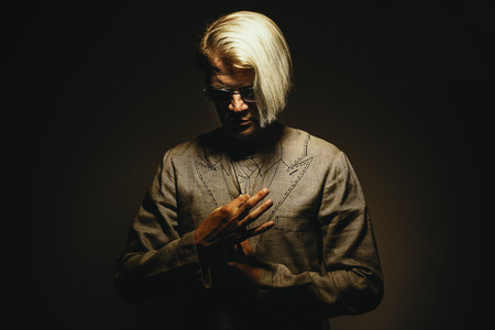 Portrait of a middle aged man in funny quasi suit and interesting haircut.の写真素材