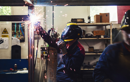 Worker in big industrial company, welding and grinding.の写真素材