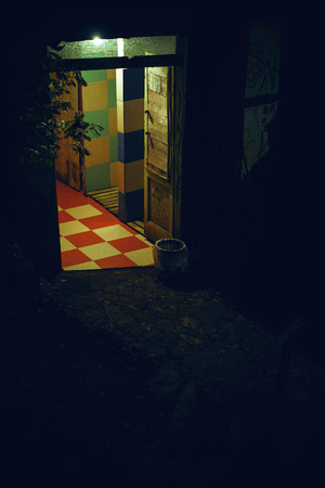 Just an entrance of an old wooden object in one corner, dark area all around.の写真素材