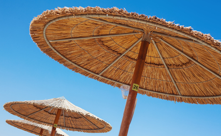 Abstract composition of sun umbrellas of reed and blue sky. の写真素材