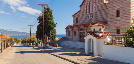 Stavros, Greece - September 04, 2017: Big Orthodox church on hill with view on main street, sea and surroundings.のeditorial素材