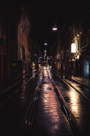 Graz, Austria - November 06, 2017: One of downtown streets during night, details of street illumination, tramways and buildings.のeditorial素材