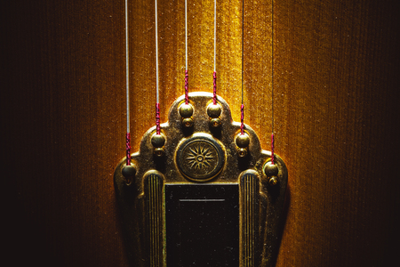 Closeup view of tailpiece of an old dusty gypsy guitar. の写真素材