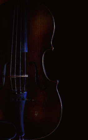 Accentuated shapes of violin with light, illuminated in dark.の写真素材