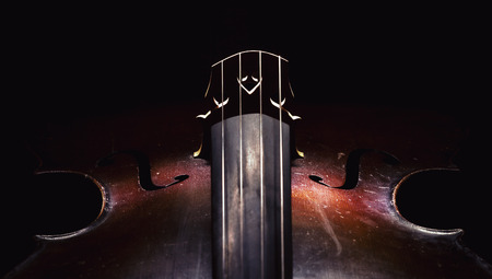 Closeup view of an old dusty cello, accentuated shapes with light. の写真素材