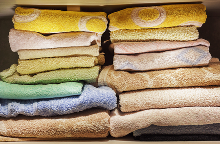 A lot of clean towels on white shelves in bathroom. の写真素材