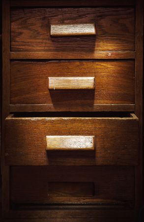 Closeup view of old wooden closet with four drawers, one is opened. の写真素材