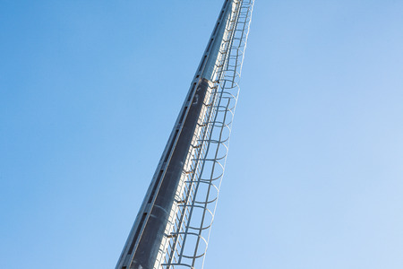 Conceptual composition of high metal ladders and blue sky. の写真素材