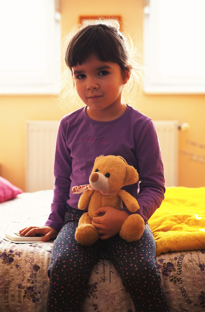 Small girl and bear toy playing and posing. の写真素材