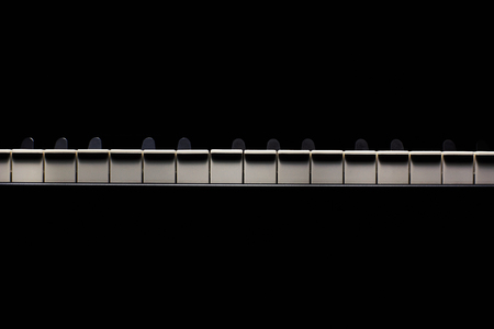 Black and white piano keys in dark ambiance. Accentuated highlights. の写真素材