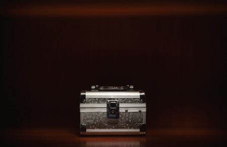 One small silver suitcase in wooden box, closeup view.の写真素材