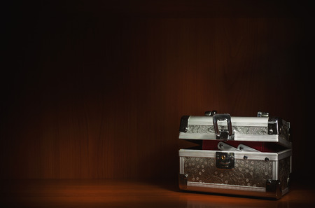 One small silver suitcase in wooden box, closeup view.の写真素材