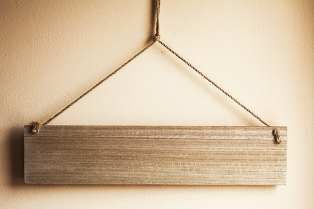 Abstract composition of small wooden board hanged on wall with ropes.の写真素材