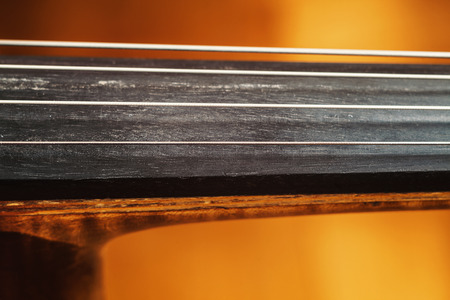 Details of an old dusty cello, closeup view on strings and body.の写真素材