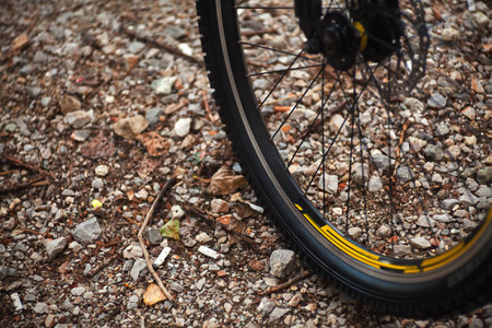 Details of sport bicycle wheel on rural road.