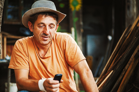 Portrait of an ordinary country man in Serbia, working and communicating with mobile.の写真素材