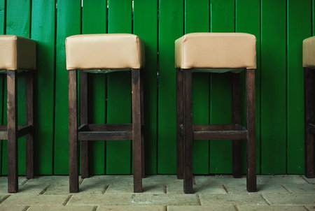 Details of empty bar chairs in a restaurant, outdoor scene during day.