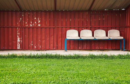 Bench for reserve football players, old and ruined during day.の写真素材