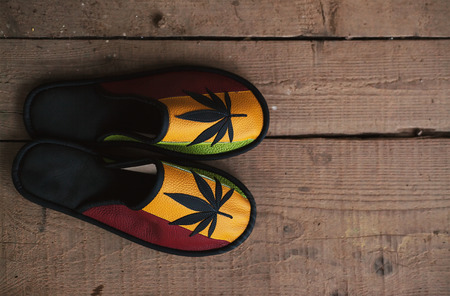 Brand new colorful shoes with marijuana symbol on top, on old wooden floor.の写真素材