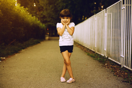 Portrait of a small girl, posing in park during evening hours.の写真素材