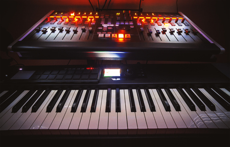 Closeup view on small modern home music studio, keyboard, mixing console and computer.の写真素材