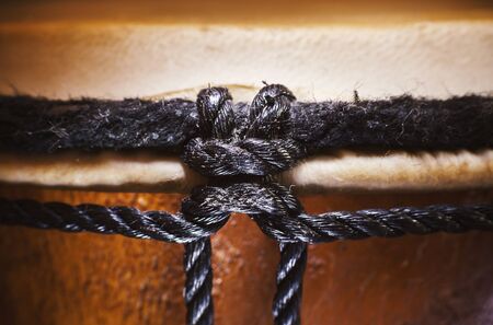 Black ropes of a wooden djembe, closeup view.の写真素材