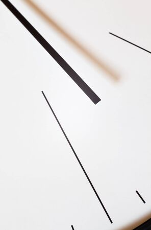 Closeup view of a simple wall watch, details of minute and hour hands on whiteの写真素材
