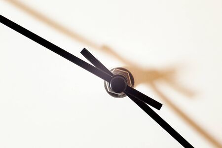 Closeup view of a simple wall watch, details of minute and hour hands on whiteの写真素材