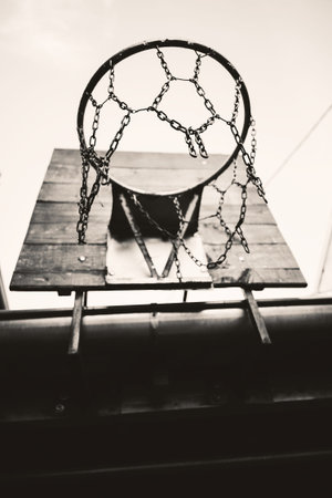 Details of an old  backyard basketball hoop, hanged on roof of a house, day scene.